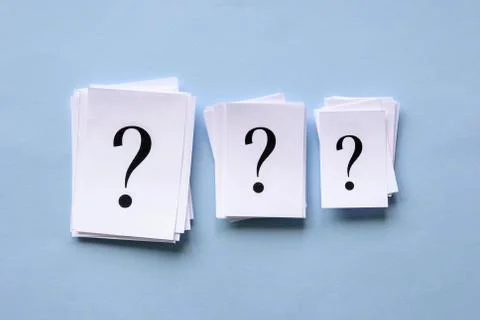 Three stacked heaps of paper with question marks Stock Photos