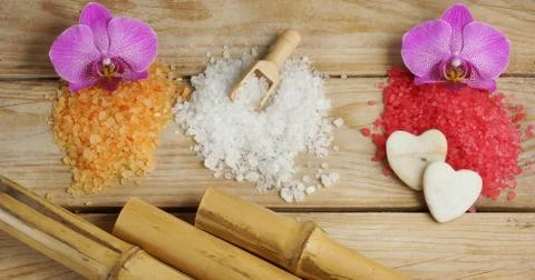 Three stacks of bath salt of different colors with bamboo and orchid on a woo Stock Photos