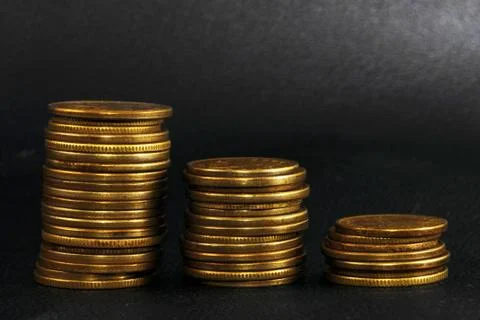 Three stacks of coins on black leather Foto stock