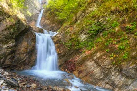 Three-stage waterfall in the spring in the mountains Stock Photos