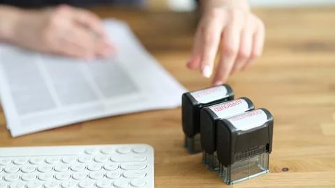 Three stamp approved completed canceled on a businesswoman desk 스톡 사진