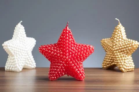 Three star shaped candles on table Stock Photos