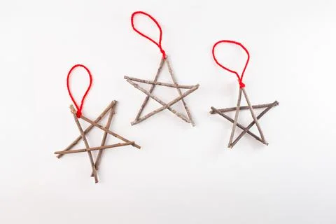 Three star shaped figures made from twigs, tied at points, with red string .. Stock Photos