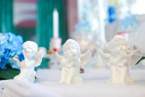 Three statues of angels on the table Stock Photos