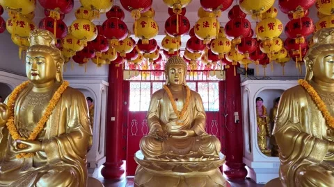 Three statues of Buddha are sitting on pedestals in a room Видео 318101410
