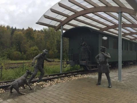 Three statues with an old steam train. Stock Photos