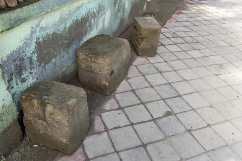 Three stone blocks are sitting on a brick sidewalk Foto stock