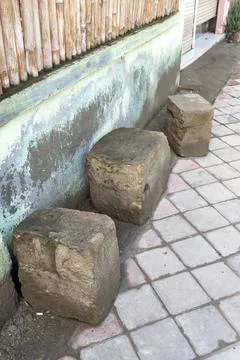 Three stone blocks are sitting on a brick sidewalk Stock Photos