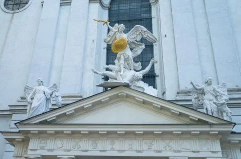 Three stone statues with gold shield and sword on the roof of church in Vienn Stock Photos
