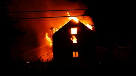 Three story building fully involved in flames at night in dramatic fire Stock Footage 99010242