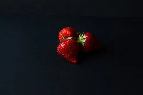 Three strawberries on a black background Foto stock