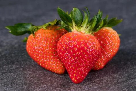Three strawberries on gray stone 写真素材