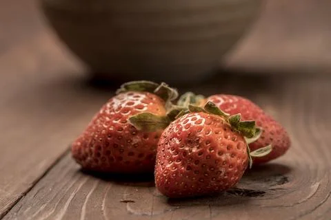 Three strawberries on a table. Stock Photos