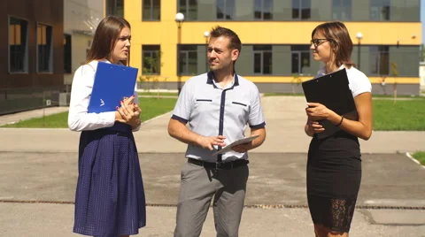 Three students are walking through campus and communicate Stock Footage 67385890