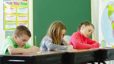 Three students in classroom doing schoolwork Stock Footage 80131448