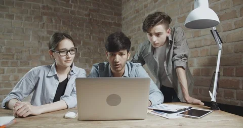 Three students delighted or surprised with success of their project. teens Stock Footage 93870133