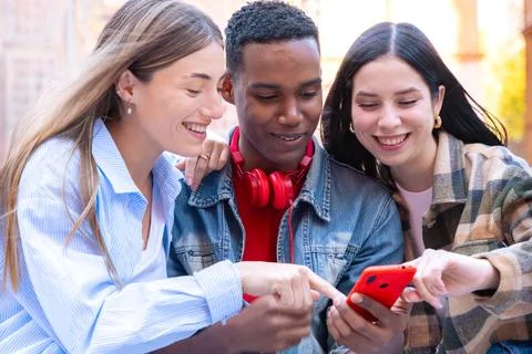 Three students having fun with mobile phones creating content on social media. Stock-Fotos