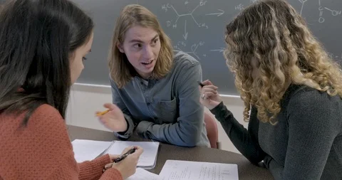 Three students learning and helping each other understand a complex lesson Stock Footage 105911001