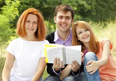 Three students at outdoor doing homework. Stock Photos