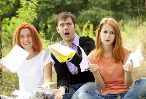 Three students at outdoor doing homework. Stock Photos
