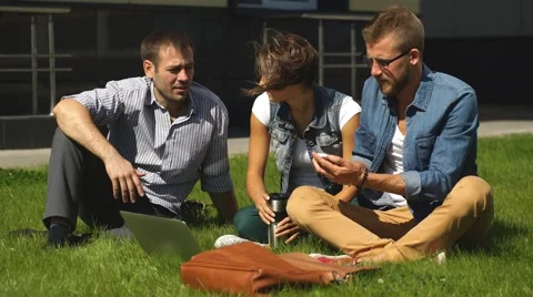 Three students sitting on lawn Stock Footage 67832175