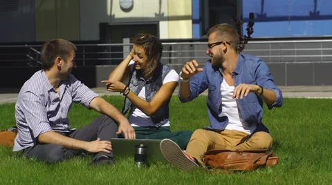 Three students sitting on lawn Stock Footage 67832706