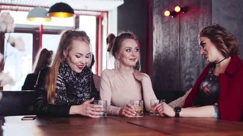 Three stylish housewives having a rest in a bar, drinking cocktails and talking Stock Footage 74007777