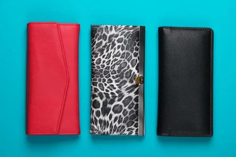 Three stylish wallets on blue background. Fashion minimalism. Top view 库存照片