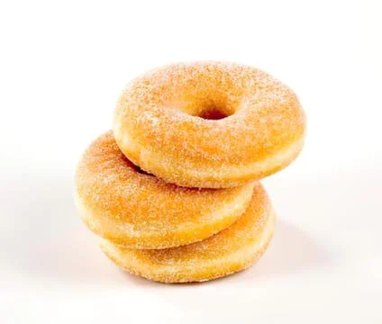 Three sugared doughnuts stacked on a clean surface Stock Photos
