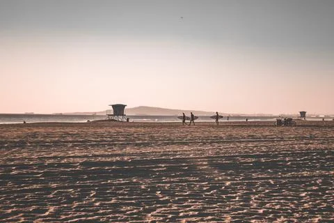 Three surfers walking along the beach in California Stock Photos