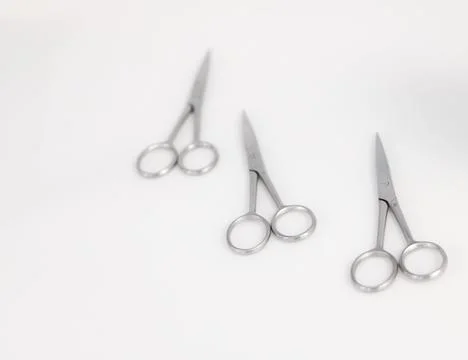 Three surgical scissors placed on a white surface. Foto stock