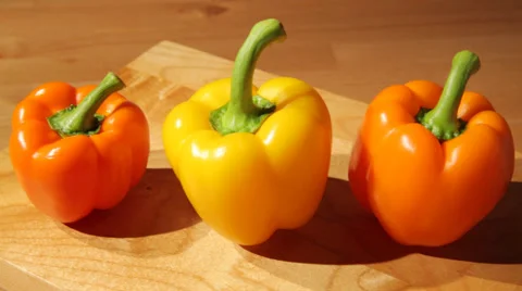 Three sweet peppers on a board Stock Footage 51103812
