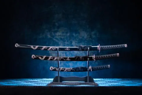Three swords on stand, with dramatic blue light Stock Photos