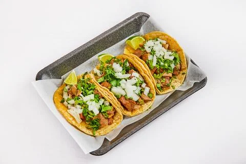 Three tacos on white paper on black tray with lengua meat Stock Photos