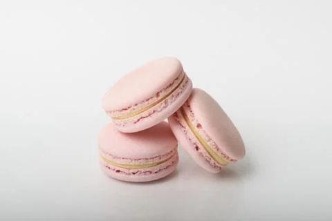 Three tasty macarons on the light background. Stock Photos