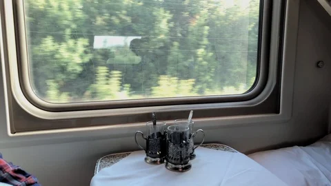 Three tea mugs on a table with a tablecloth in the russian train Vidéo 95002431