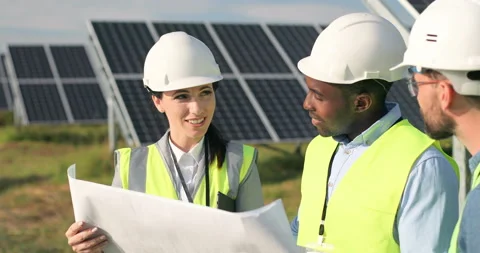 Three technical engineers review plan on paper and discuss. Two men listen to Stock Footage 139507540
