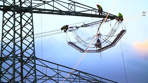 Three technicians working on a high voltage line on a power pole Stock Footage 163083772