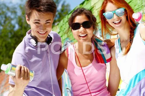 Three teenagers outdoors looking at camera and smiling Stock Photos