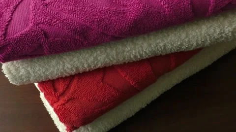 Three terry multi-coloured towels on a table Video stock 49883699