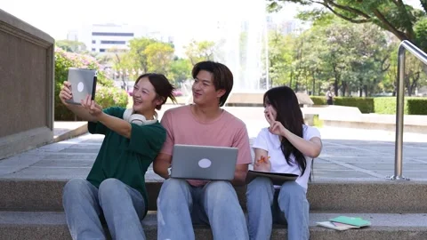Three Thai University Students Studying Outdoors and Taking a Group Selfie Stock Footage 328498371