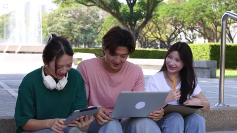Three Thai University Students Studying Together Outdoors with Laptop and Tablet Stock Footage 328786718