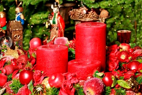 Three thick red candles surrounded by Christmas decorations and fairytale fig Stock Photos