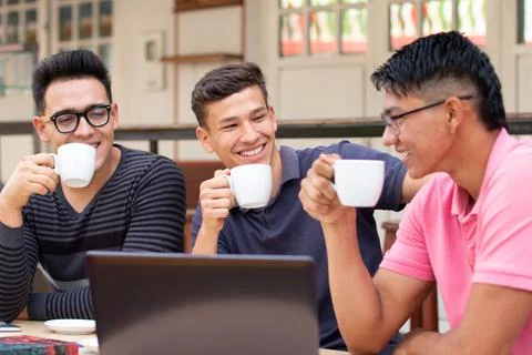 Three thoughtful students drinking in an outdoor Latin cafe Stock Photos