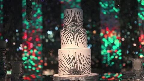 Three tier celebration cake decorated with silver glitter sunburst patterns and Stock Footage 331615924