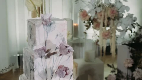 Three-tier elegant wedding cake with delicate edible decorations isolated on a p Stock Footage 254861835