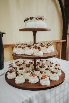 Three-tiered dessert display featuring meringue cakes topped with fresh ber.. Foto stock