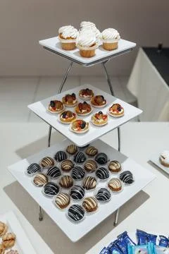 Three-tiered stand holds assorted pastries Stockfoto's