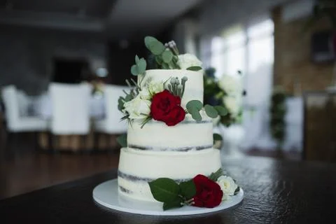 Three-tiered wedding cake decorated with fresh flowers. Fashion cake Stock Photos