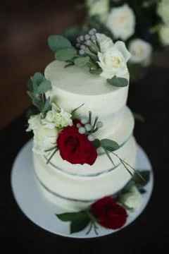 Three-tiered wedding cake decorated with fresh flowers. Fashion cake Stock Photos